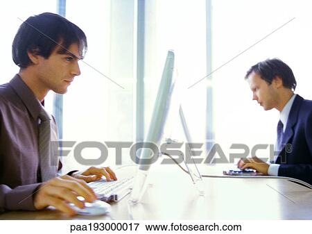 Stock Photo - Businessmen working at computers.. Fotosearch