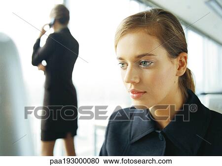 Businesswoman on cell phone, rear view, in background, blurred, businesswoman working in foreground, close-up. View Large Photo Image Stock Image - Businesswoman on cell phone, rear view, in background, blurred, businesswoman working in foreground, close-up.. Fotosearch