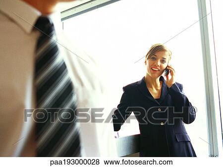Businesswoman on phone, businessman's chest in foreground, close up. View Large Photo Image Stock Photo - Businesswoman on phone, businessman's chest in foreground, close up.. Fotosearch