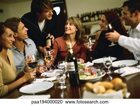 Group of young people around table, drinking wine View Large Photo Image Stock Image - Group of young people around table, drinking wine. Fotosearch