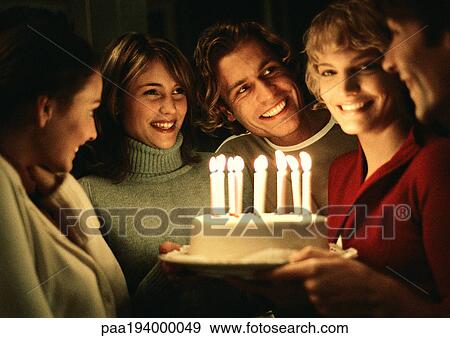 Woman holding birthday cake in group. View Large Photo Image Stock Photo - Woman holding birthday cake in group.. Fotosearch