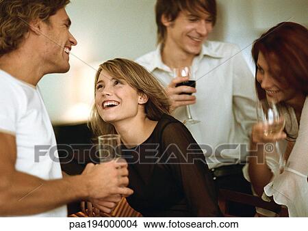 Picture - Young men and women drinking at bar. Fotosearch
