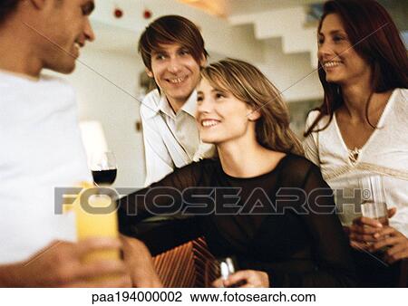 Young men and women drinking at bar View Large Photo Image Stock Image - Young men and women drinking at bar. Fotosearch