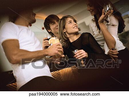 Young men and women drinking at bar View Large Photo Image Stock Photography - Young men and women drinking at bar. Fotosearch