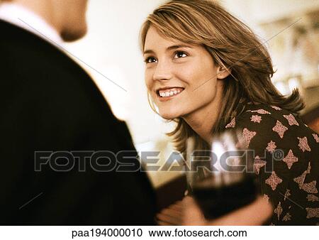 Young woman smiling at man with drink. View Large Photo Image Stock Image - Young woman smiling at man with drink.. Fotosearch