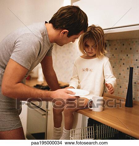 Picture - Daughter sitting on counter, father standing leaning toward her. Fotosearch