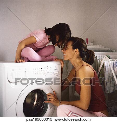Daughter sitting on washing machine, head to head with mother. View Large Photo Image Stock Photography - Daughter sitting on washing machine, head to head with mother.. Fotosearch