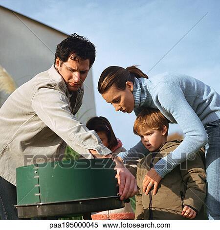 Family standing around outside grill View Large Photo Image Stock Photography - Family standing around outside grill. Fotosearch
