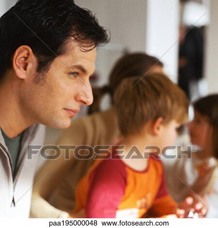 Father sitting with family, close-up View Large Photo Image Stock Photo - Father sitting with family, close-up. Fotosearch