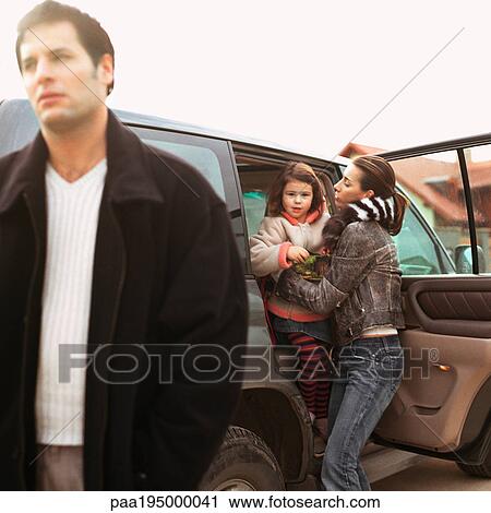 Mother getting daughter out of car, father walking. View Large Photo Image Stock Image - Mother getting daughter out of car, father walking.. Fotosearch