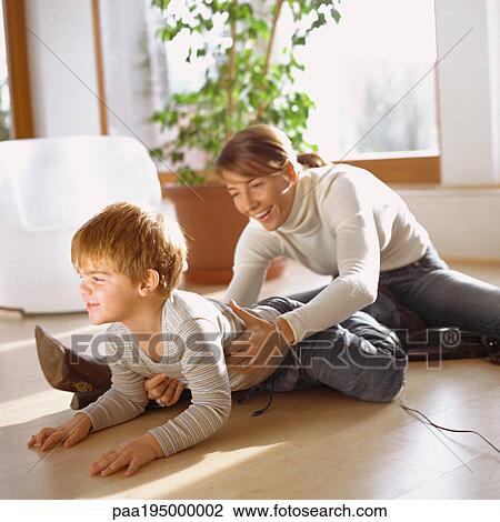 Mother grasping son, on floor View Large Photo Image Stock Image - Mother grasping son, on floor. Fotosearch