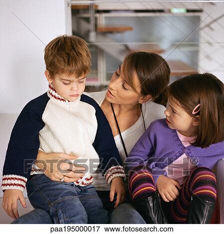 Stock Photo - Mother sitting with children, looking at son.. Fotosearch