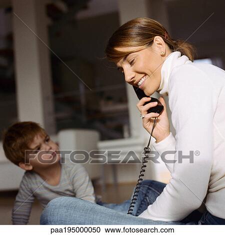 Son looking up at mother on phone View Large Photo Image Stock Image - Son looking up at mother on phone. Fotosearch