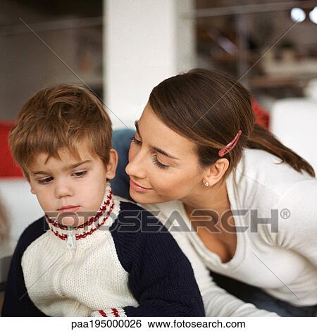 Stock Photograph - Woman leaning over son's shoulder.. Fotosearch