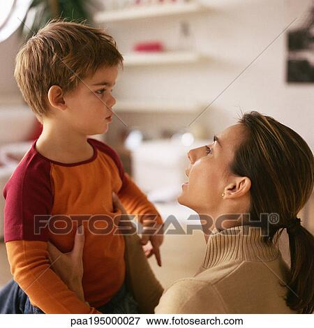 Stock Photo - Woman picking up little boy, talking to him.. Fotosearch