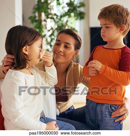 Woman with arms around two children, looking at girl blowing nose. View Large Photo Image Stock Image - Woman with arms around two children, looking at girl blowing nose.. Fotosearch