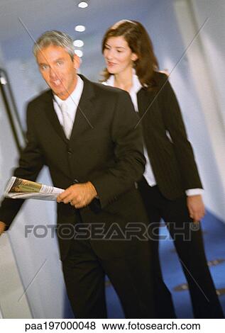 Stock Photo - Businessman and businesswoman walking together, blurred. Fotosearch