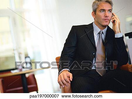 Businessman sitting, talking on cell phone. View Large Photo Image Stock Photo - Businessman sitting, talking on cell phone.. Fotosearch