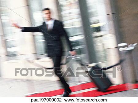 Businessman with luggage, arm extended, blurred. View Large Photo Image Stock Image - Businessman with luggage, arm extended, blurred.. Fotosearch
