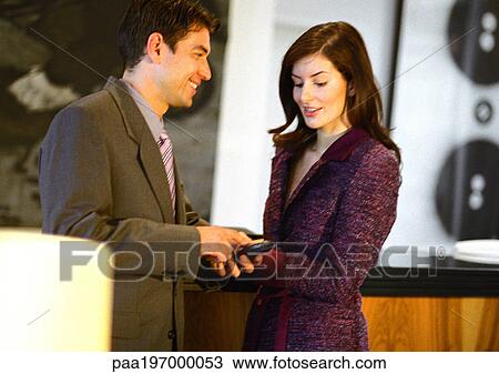 Businesswoman looking down at businessman's cell phone. View Large Photo Image Stock Image - Businesswoman looking down at businessman's cell phone.. Fotosearch