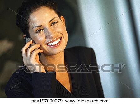 Stock Photo - Businesswoman smiling, talking on cell phone, portrait.. Fotosearch