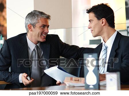 Stock Photo - Men sitting together smiling. Fotosearch
