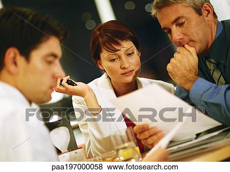 Stock Photo - People looking at documents. Fotosearch