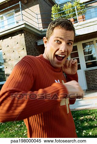 Man standing in front of house, looking surprised. View Large Photo Image Stock Photography - Man standing in front of house, looking surprised.. Fotosearch