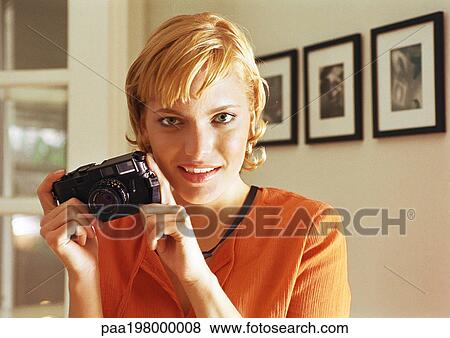 Young woman holding camera. View Large Photo Image Stock Photo - Young woman holding camera.. Fotosearch