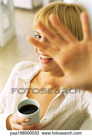 Young woman smiling, head and shoulders, in background, face obscured by hand, blurred, in foreground, high angle view View Large Photo Image Stock Image - Young woman smiling, head and shoulders, in background, face obscured by hand, blurred, in foreground, high angle view. Fotosearch