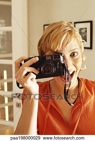 Young woman taking photo, head and shoulders View Large Photo Image Stock Photo - Young woman taking photo, head and shoulders. Fotosearch