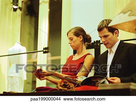 Picture - Couple at counter in clothing store.. Fotosearch
