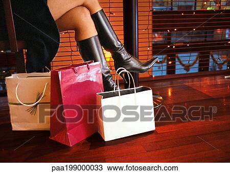 Woman in boots sitting, bags on floor to the side, lower section View Large Photo Image Stock Image - Woman in boots sitting, bags on floor to the side, lower section. Fotosearch