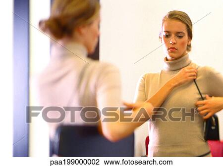Woman looking in mirror at purse. View Large Photo Image Stock Image - Woman looking in mirror at purse.. Fotosearch