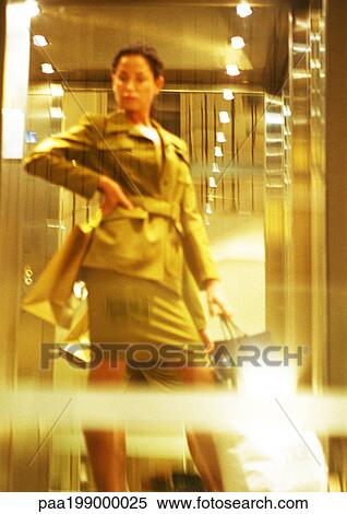 Woman standing with hand on hip, holding shopping bags, blurred. View Large Photo Image Stock Photography - Woman standing with hand on hip, holding shopping bags, blurred.. Fotosearch