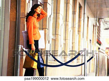 Woman walking out of store with shopping bags in hand. View Large Photo Image Stock Image - Woman walking out of store with shopping bags in hand.. Fotosearch