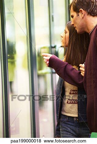 Young couple window shopping, man pointing. View Large Photo Image Stock Photo - Young couple window shopping, man pointing.. Fotosearch