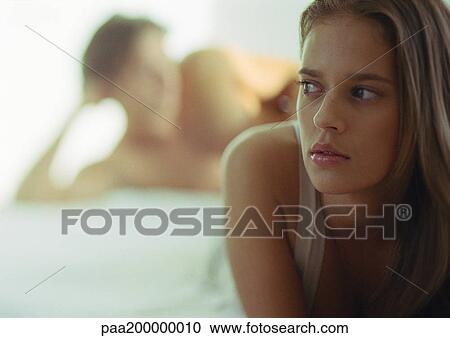 Close up of woman, man blurred in background, lying in bed. View Large Photo Image Stock Image - Close up of woman, man blurred in background, lying in bed.. Fotosearch