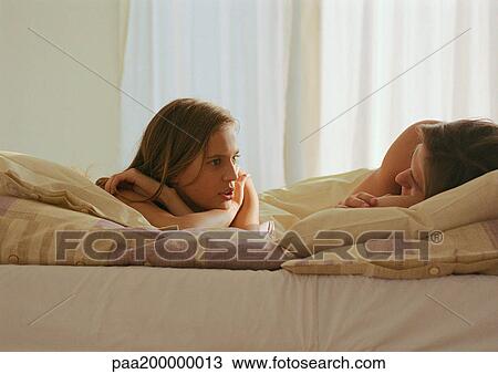 Man and woman lying in bed talking to each other. View Large Photo Image Stock Image - Man and woman lying in bed talking to each other.. Fotosearch