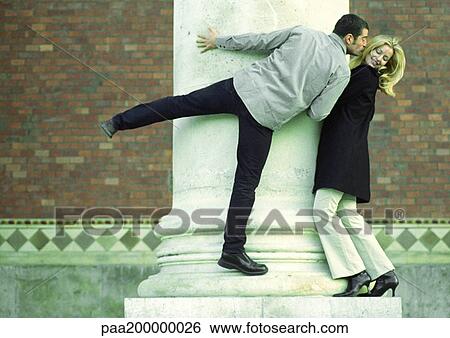 Man and woman standing on column, man stretching to kiss woman. View Large Photo Image Stock Photograph - Man and woman standing on column, man stretching to kiss woman.. Fotosearch