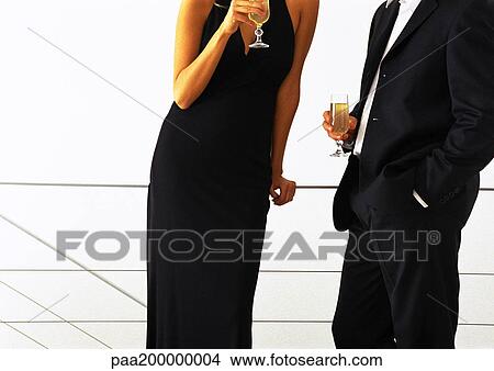 Man and woman standing together drinking champagne, mid-section. View Large Photo Image Picture - Man and woman standing together drinking champagne, mid-section.. Fotosearch