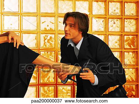 Man in suit putting a shoe on woman's foot. View Large Photo Image Stock Photo - Man in suit putting a shoe on woman's foot.. Fotosearch