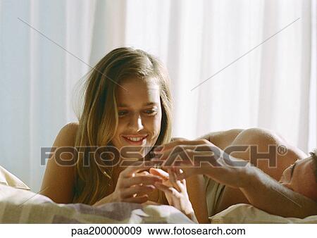 Man lying in bed touching woman's hand. View Large Photo Image Stock Photo - Man lying in bed touching woman's hand.. Fotosearch