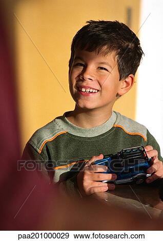 Child holding toy car, looking up. View Large Photo Image Stock Photo - Child holding toy car, looking up.. Fotosearch
