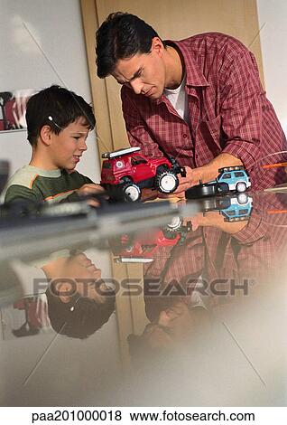 Father and son playing with toy cars. View Large Photo Image Stock Photo - Father and son playing with toy cars.. Fotosearch