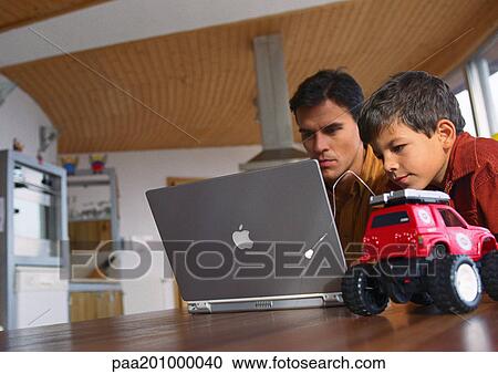Father and son working on computer together. View Large Photo Image Stock Image - Father and son working on computer together.. Fotosearch