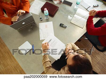 Business people sitting at table in meeting room, view from above. View Large Photo Image Stock Photo - Business people sitting at table in meeting room, view from above.. Fotosearch