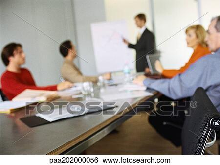 Business people sitting at table in meeting, blurred. View Large Photo Image Stock Photograph - Business people sitting at table in meeting, blurred.. Fotosearch