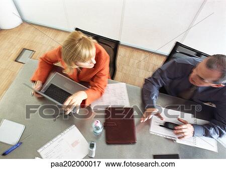 Businessman and businesswoman sitting at table talking, view from above, blurred. View Large Photo Image Stock Photo - Businessman and businesswoman sitting at table talking, view from above, blurred.. Fotosearch