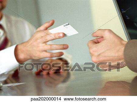 Businessman handing business card to man. View Large Photo Image Picture - Businessman handing business card to man.. Fotosearch